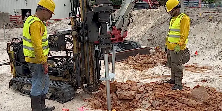commercial-helicalpier Helicon crew members inserting a helical pier into the ground.