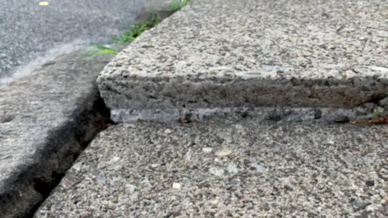 residential-sunkenconcreteslab Sunken residential concrete slab with visible separation and uneven settling caused by soil erosion