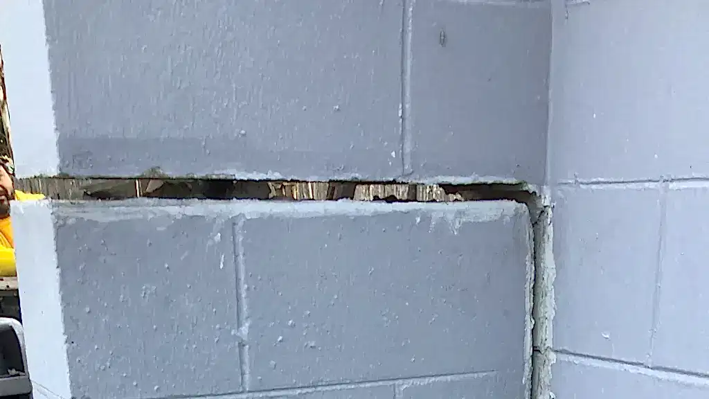 Why an Orlando Home Needed Both a Push Pier and Structural Polyurethane Foam to Stop Foundation Settlement 1 Close-up view of a large horizontal crack separating concrete block courses in a residential foundation wall, showing visible structural movement and mortar failure.