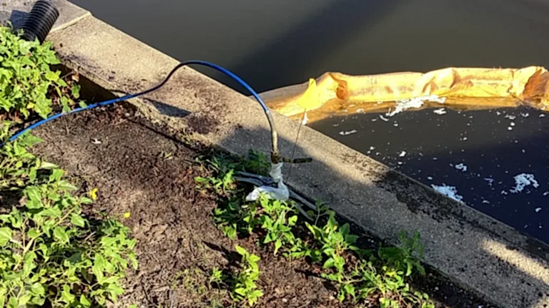 5.4residential-injectionintoseawallvoid-2 Helicon technicians injecting structural grout into a residential seawall void using high‑pressure hoses to stabilize eroded soil along the waterfront.