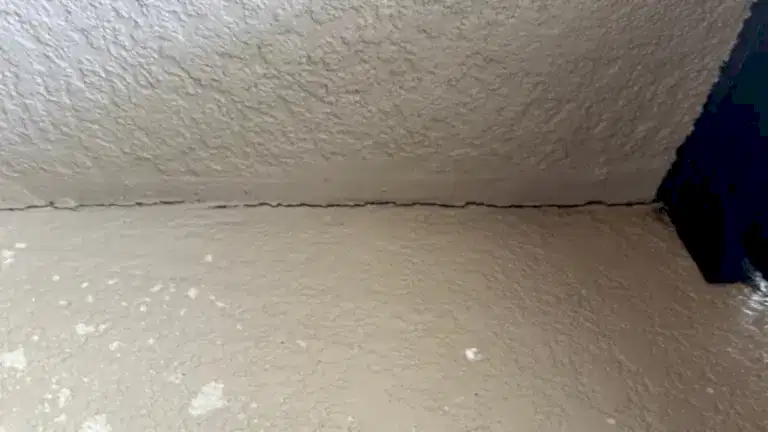 residential-crackingneartheceiling Separation crack visible where stucco ceiling meets exterior wall due to settlement